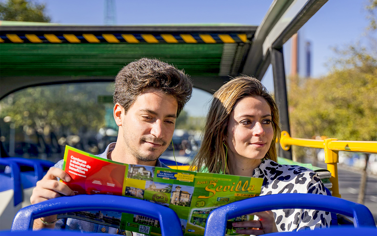 Tourists reading a map on Seville hop-on hop-off bus tour.