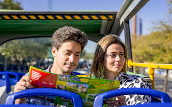 Tourists reading a map on Seville hop-on hop-off bus tour.