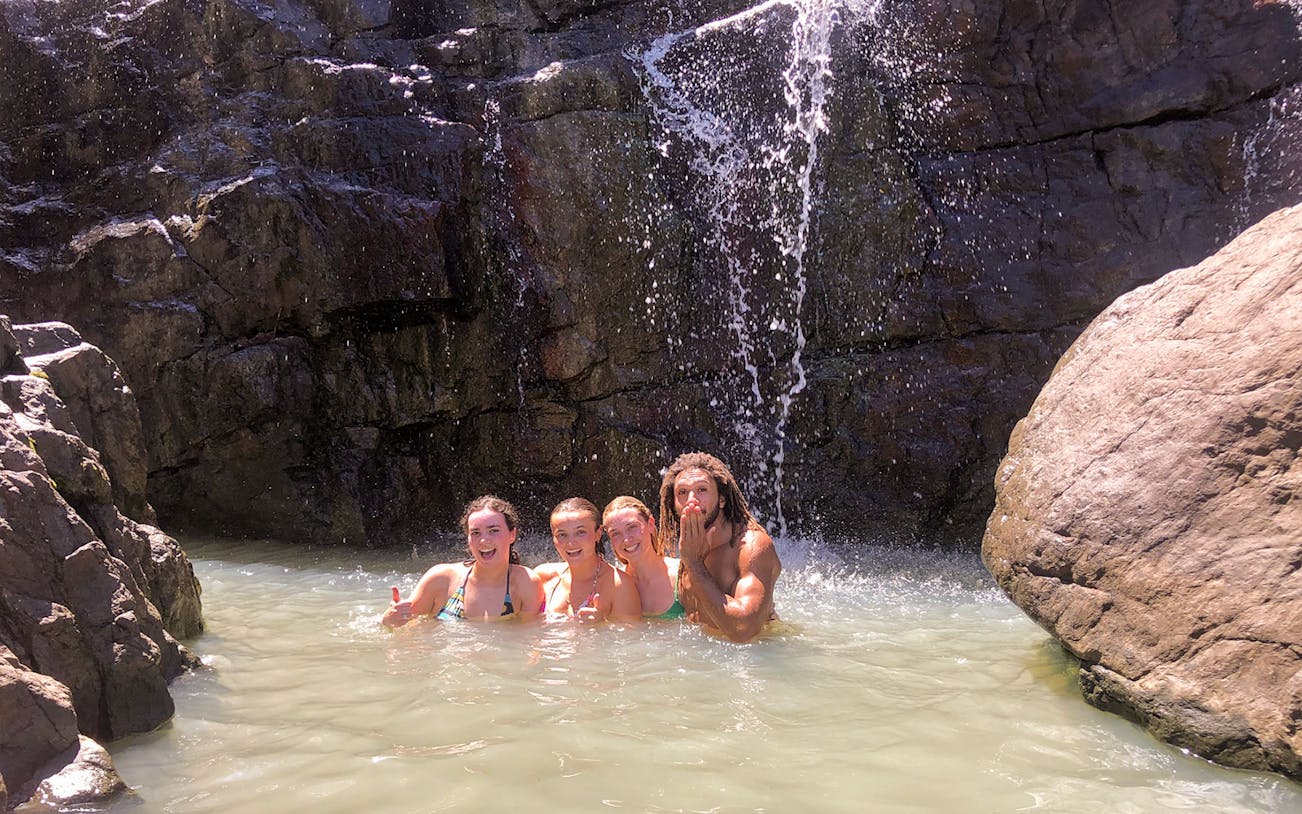 Group enjoying waterfall swim on Falls to Paradise Guided Day Tour.