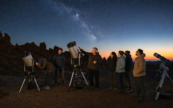 Group stargazing with telescopes at sunset in Teide National Park, Tenerife.