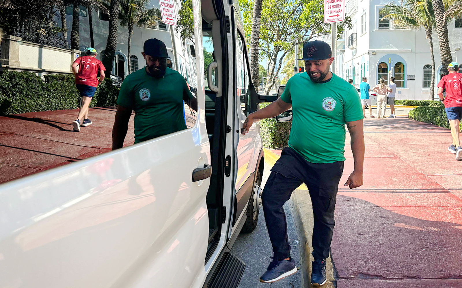 Guest entering a tour van on a sunny street.