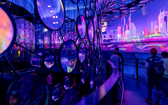 Visitors exploring a vibrant, futuristic exhibit at Expo City Dubai.