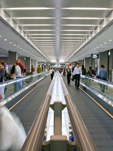 Passengers on a moving walkway at Narita Airport terminal.