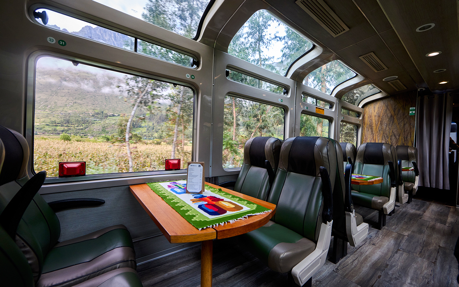 Interior of train to Machu Picchu with panoramic windows and scenic mountain views.