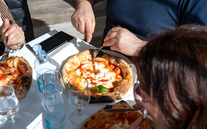 Tourists dining on authentic Naples pizza in Italy.