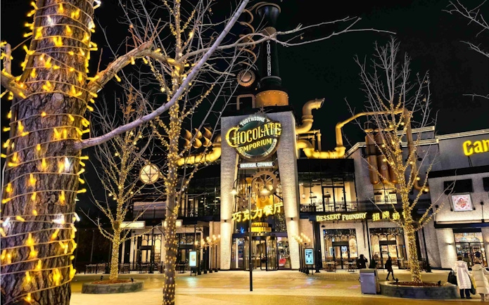 Toothsome Chocolate Emporium at Universal Studios CityWalk Beijing illuminated at night.