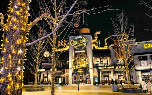 Toothsome Chocolate Emporium at Universal Studios CityWalk Beijing illuminated at night.