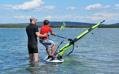 Windsurfing lesson with instructor and child in Delta Neretva, Croatia.