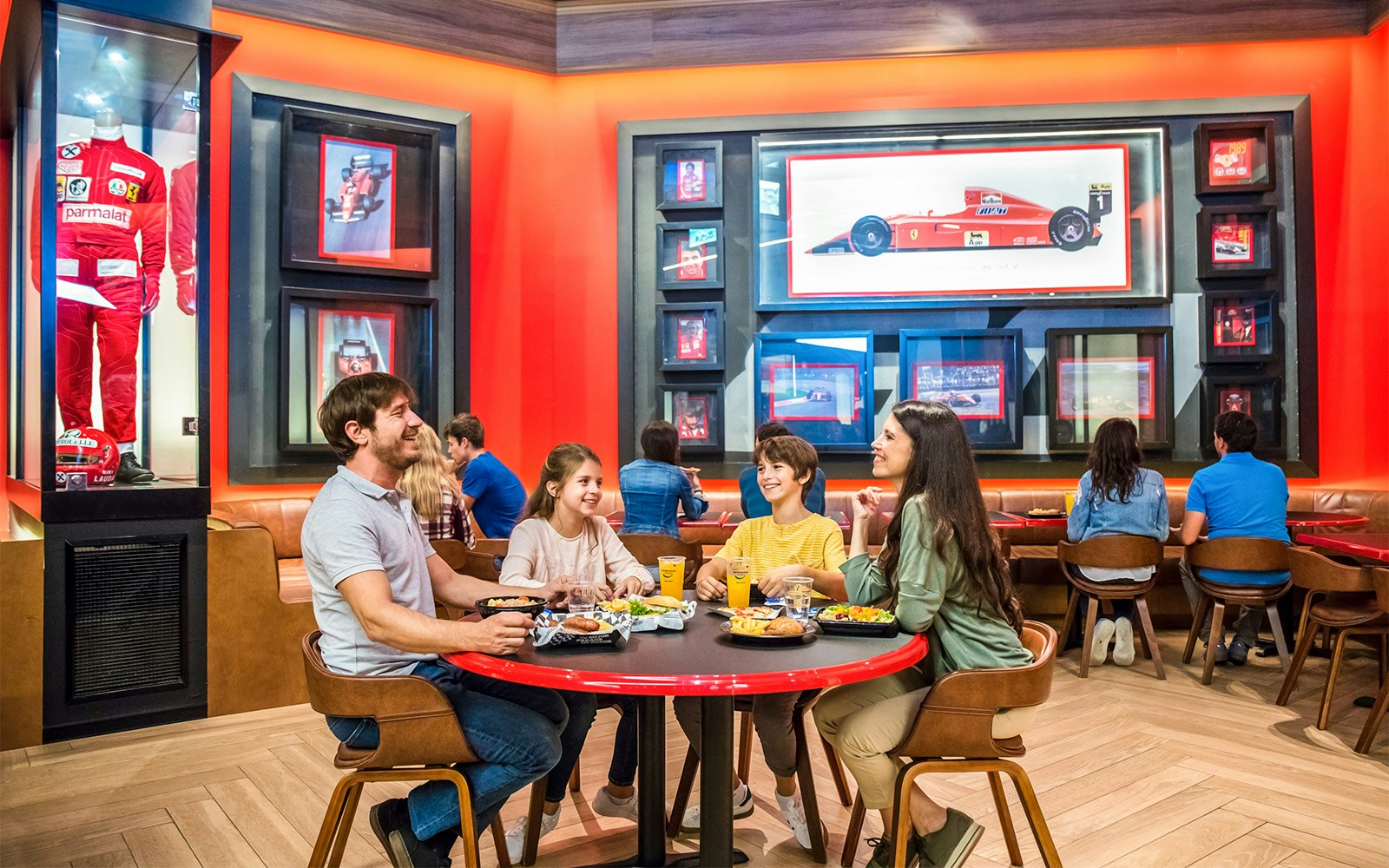 Family dining at Ferrari Land PortAventura restaurant with racing memorabilia.