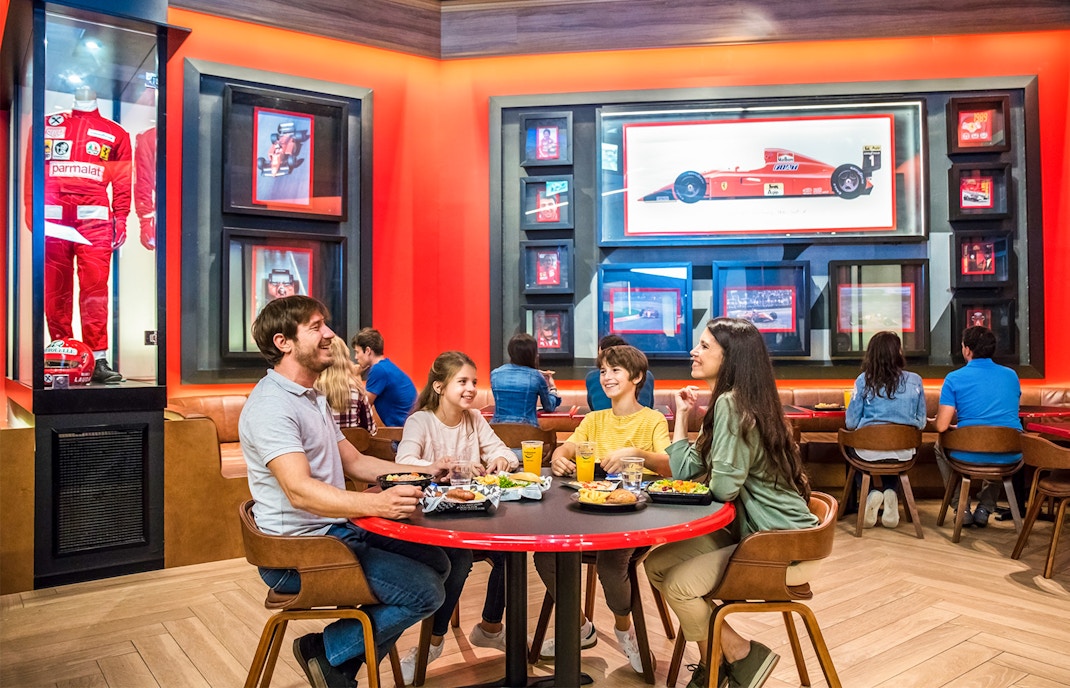Ferrari Land PortAventura dining area with red and white decor, showcasing restaurant seating.