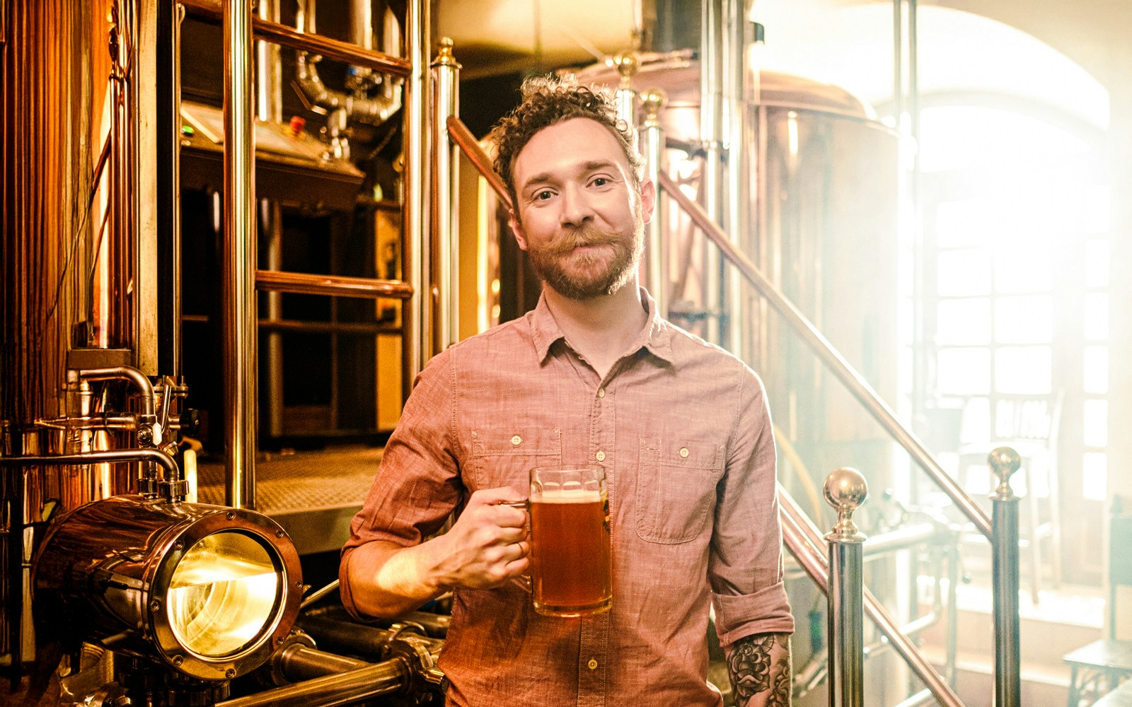 Man holding a beer in a craft brewery.