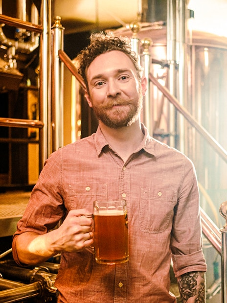 Man holding a beer in a craft brewery.