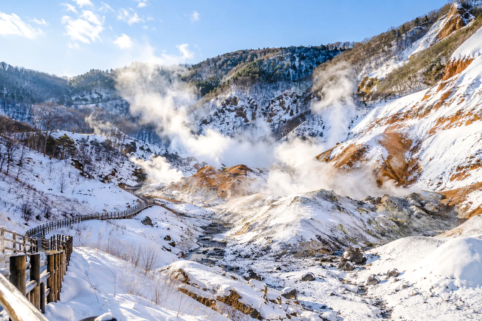 Noboribetsu's snow-covered geothermal valley with steam rising, Hokkaido winter tour.