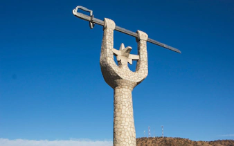 Monumento a la Victoria de Chacabuco statue with sword against blue sky.