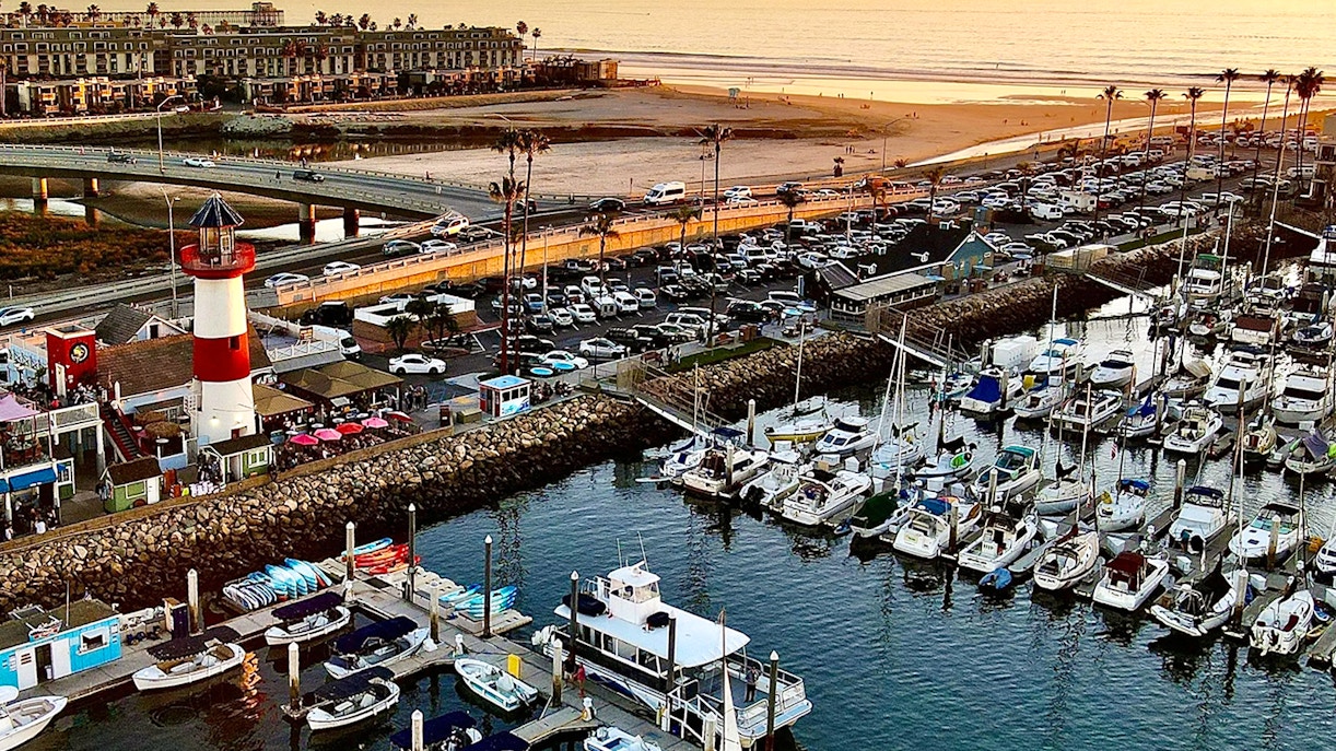Marina with boats and lighthouse at sunset, San Diego, for luxury whale watching tour.