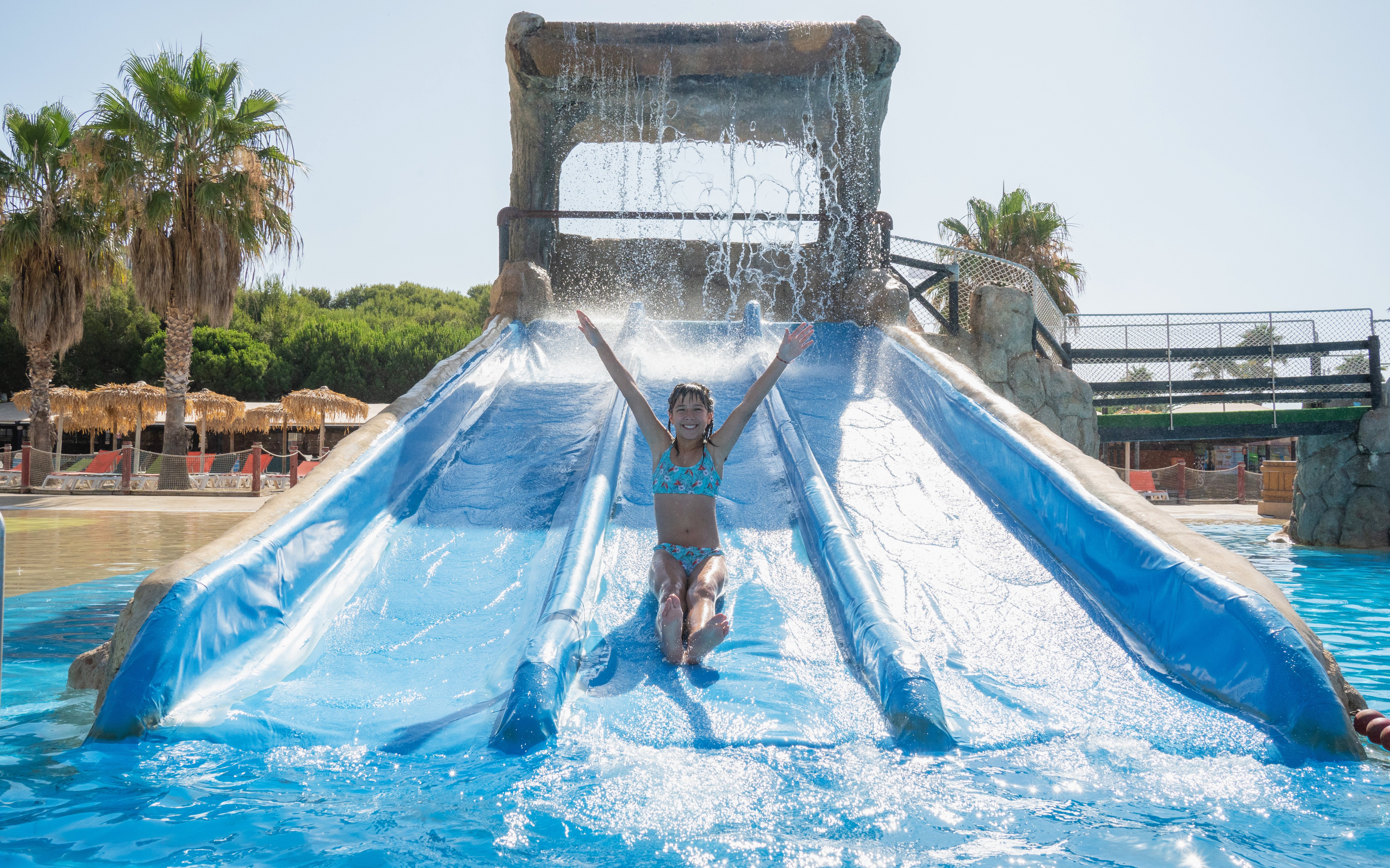 Child enjoying a water slide at Aquopolis Costa Daurada, Tarragona.