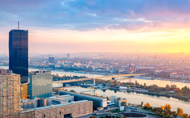 Sunset view over Vienna with Danube River and city skyline.