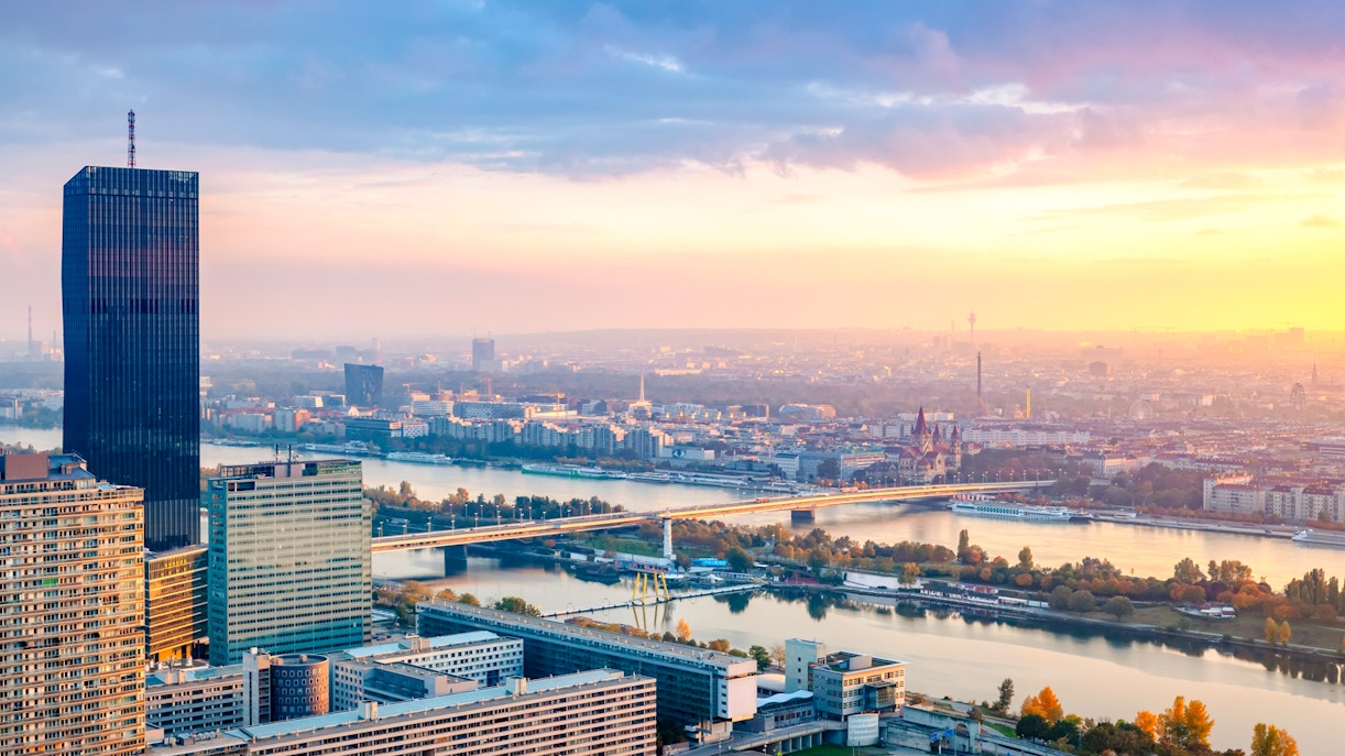 Danube Canal cruise at sunset with Vienna skyline in the background.