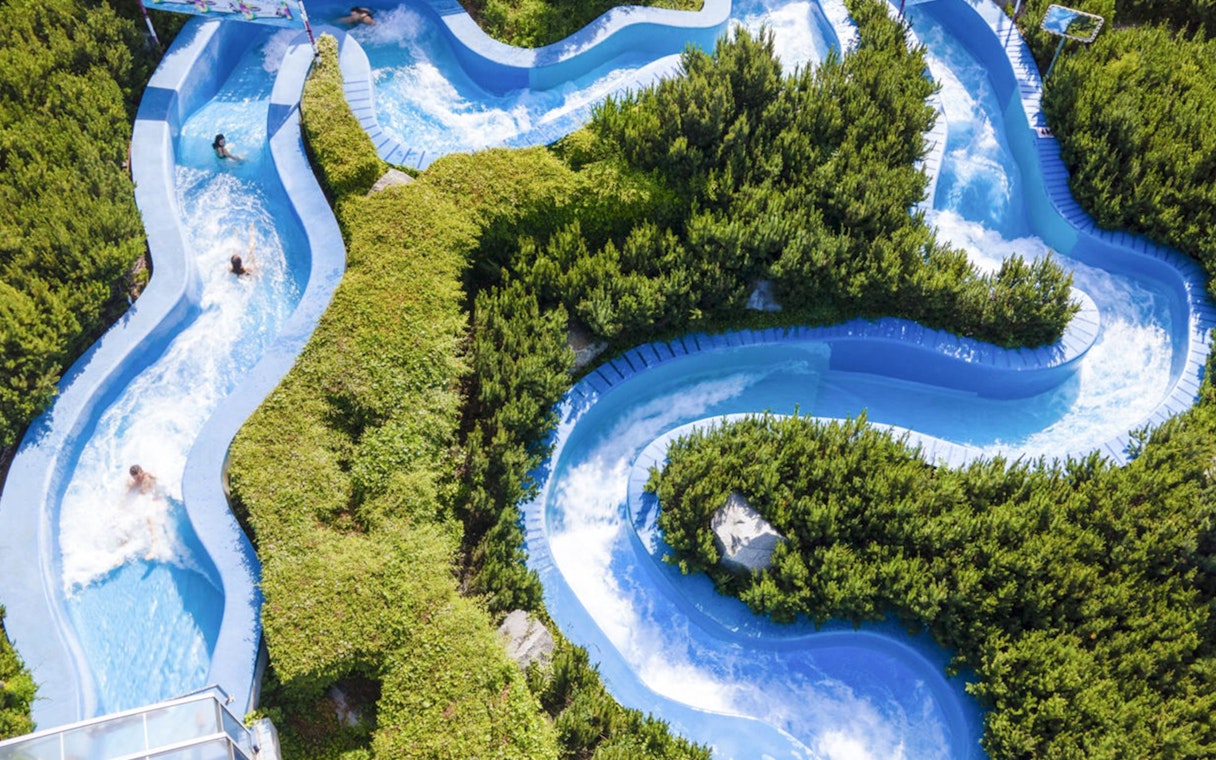 Water slides winding through greenery at Aquapalace Water World, Prague.
