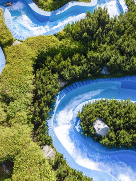 Water slides winding through greenery at Aquapalace Water World, Prague.