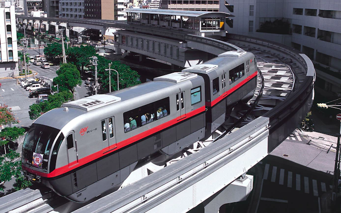 Okinawa Monorail train traveling through urban landscape in Naha, Japan.