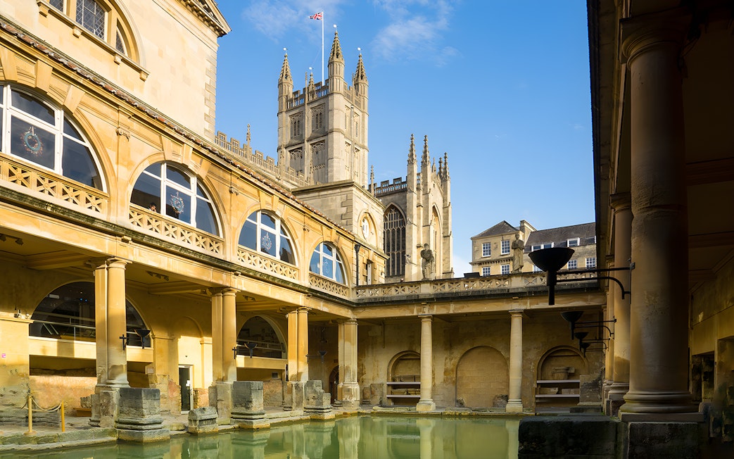 Roman Baths in Bath with Bath Abbey in the background, part of a guided day tour from London.