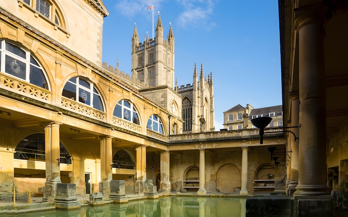 Roman Baths in Bath with Bath Abbey in the background, part of a guided day tour from London.