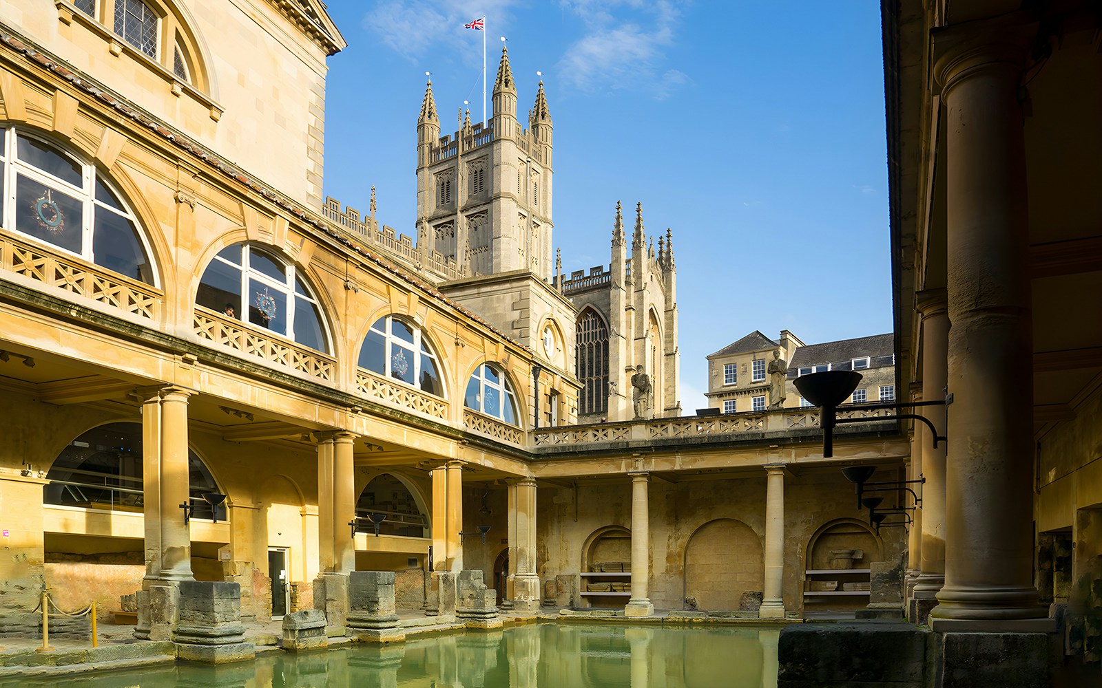 Roman Baths in Bath with Bath Abbey in the background, part of a guided day tour from London.