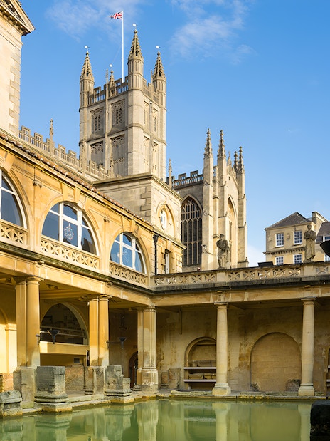 Roman Baths in Bath with Bath Abbey in the background, part of a guided day tour from London.
