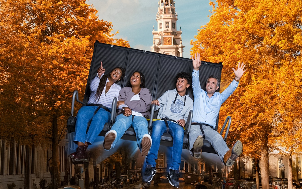 Tourists experiencing 5D ride at This Is Holland with Amsterdam tower in background.