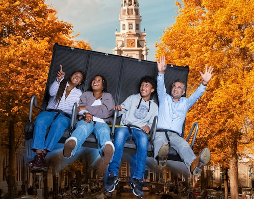 Tourists experiencing 5D ride at This Is Holland with Amsterdam tower in background.