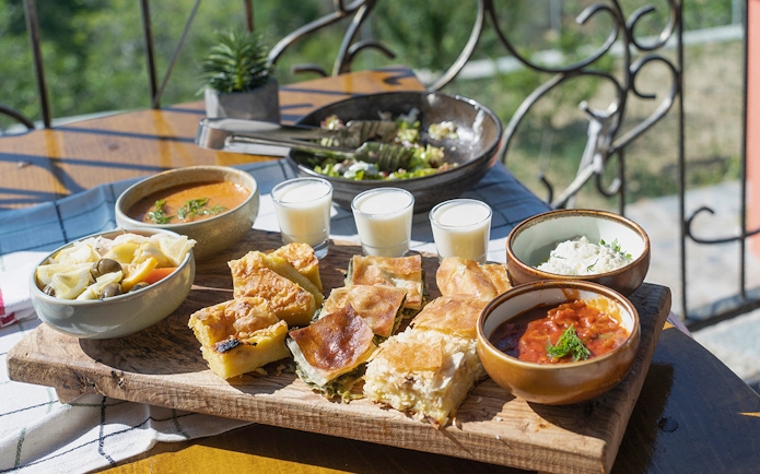 Traditional Albanian lunch spread with byrek, soup, salad, and drinks during Blue Eye Kayak Tour in Saranda.