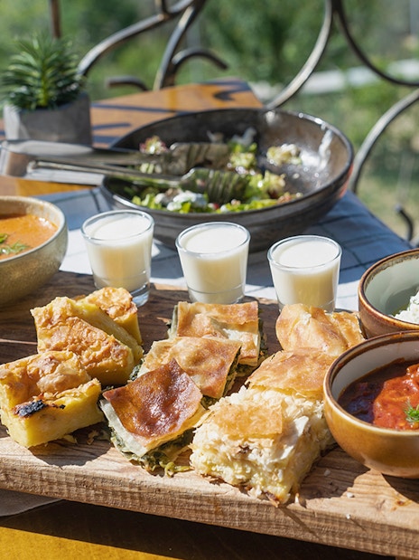 Traditional Albanian lunch spread with byrek, soup, salad, and drinks during Blue Eye Kayak Tour in Saranda.