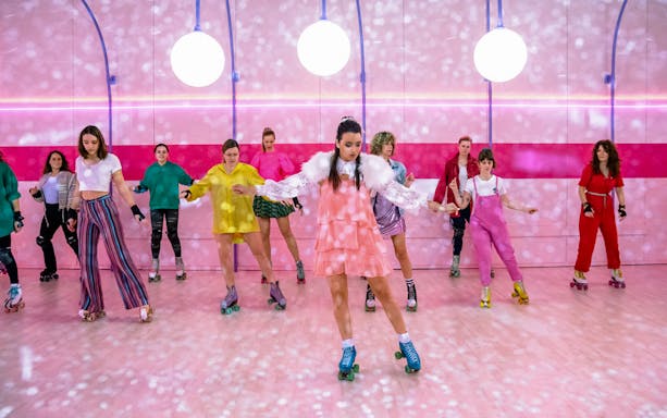 Group roller skating at Amsterdam Roller Dreams rink with colorful outfits.