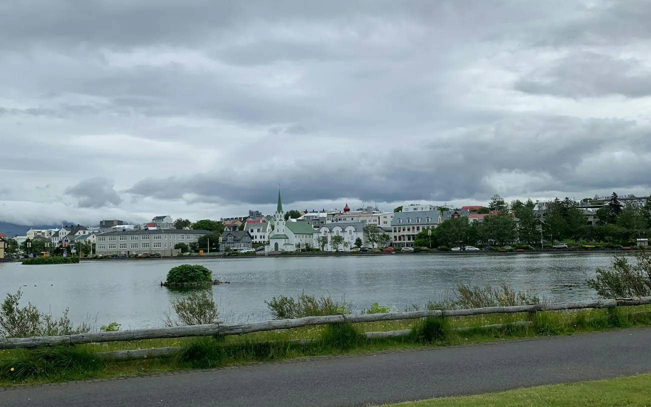 Reykjavík cityscape with Tjörnin lake and Fríkirkjan church in the background.