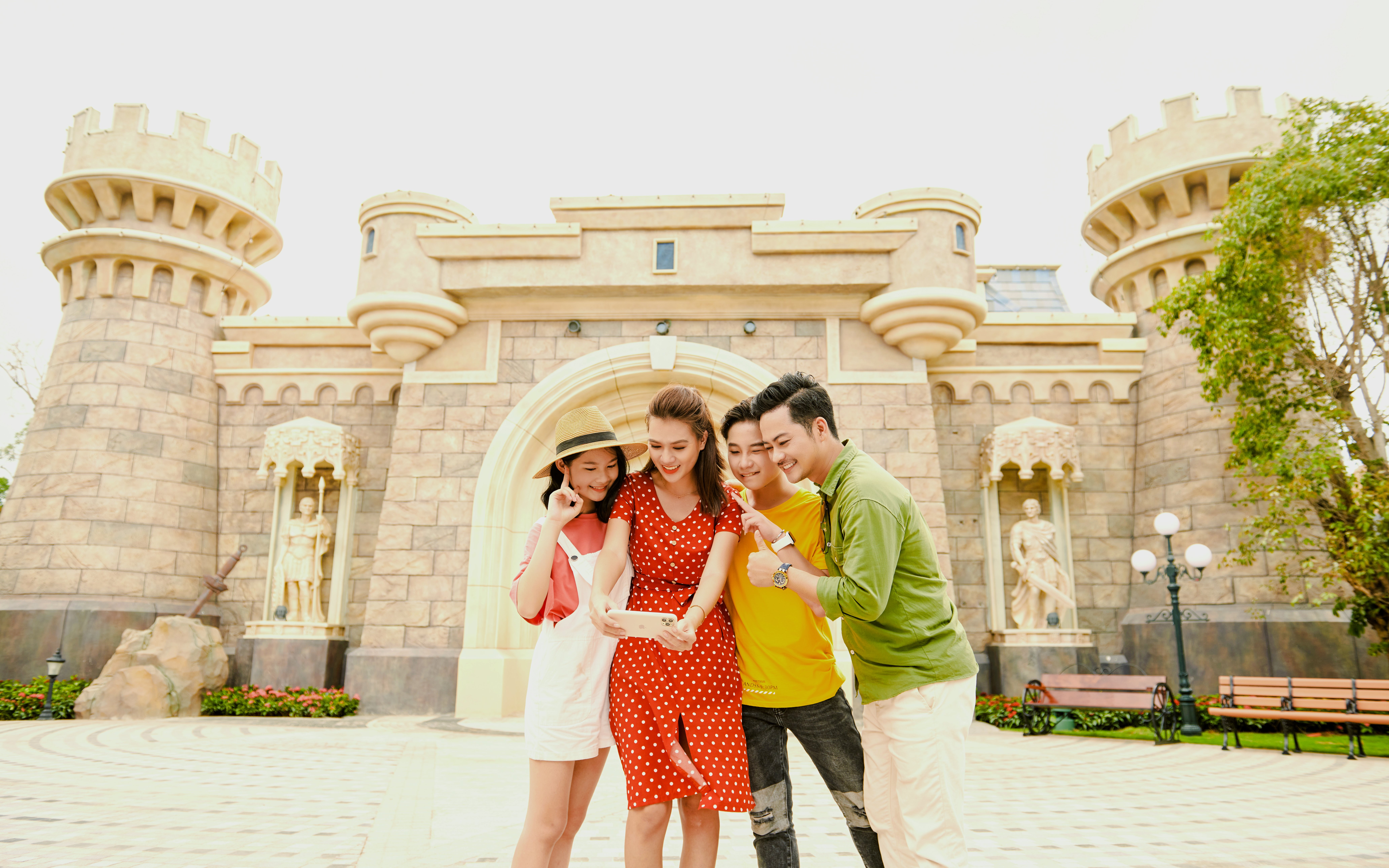 Tourists taking a selfie in front of a castle at Fairy World VinWonders.