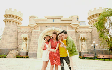 Tourists taking a selfie in front of a castle at Fairy World VinWonders.