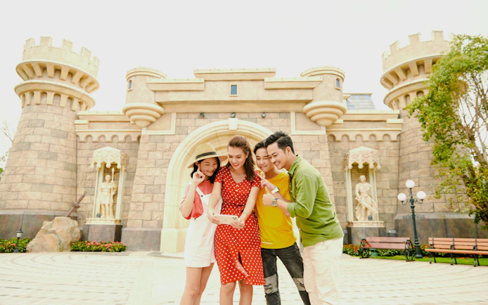 Tourists taking a selfie in front of a castle at Fairy World VinWonders.