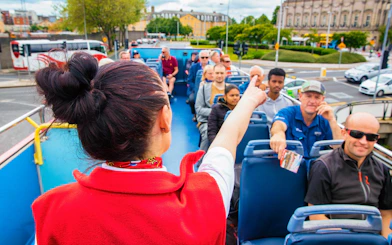 Tour guide pointing out sights on a Dublin hop-on-hop-off bus tour.