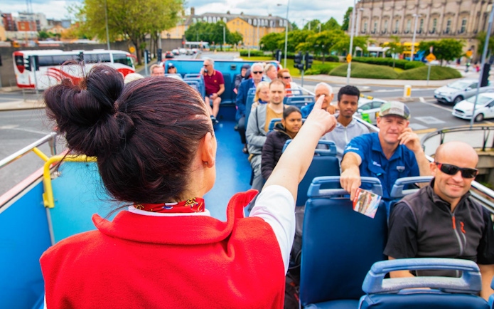 Tour guide pointing out sights on a Dublin hop-on-hop-off bus tour.