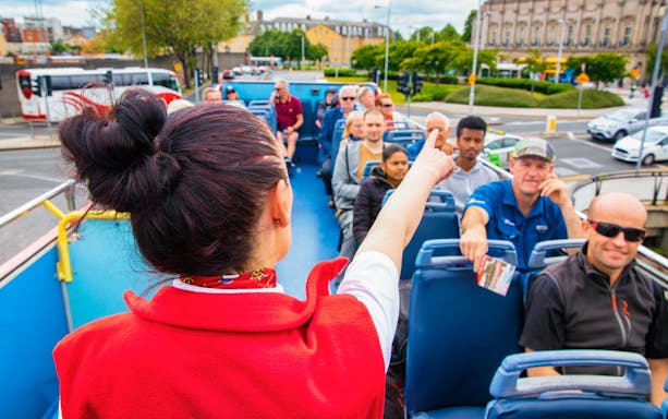 Tour guide pointing out sights on a Dublin hop-on-hop-off bus tour.