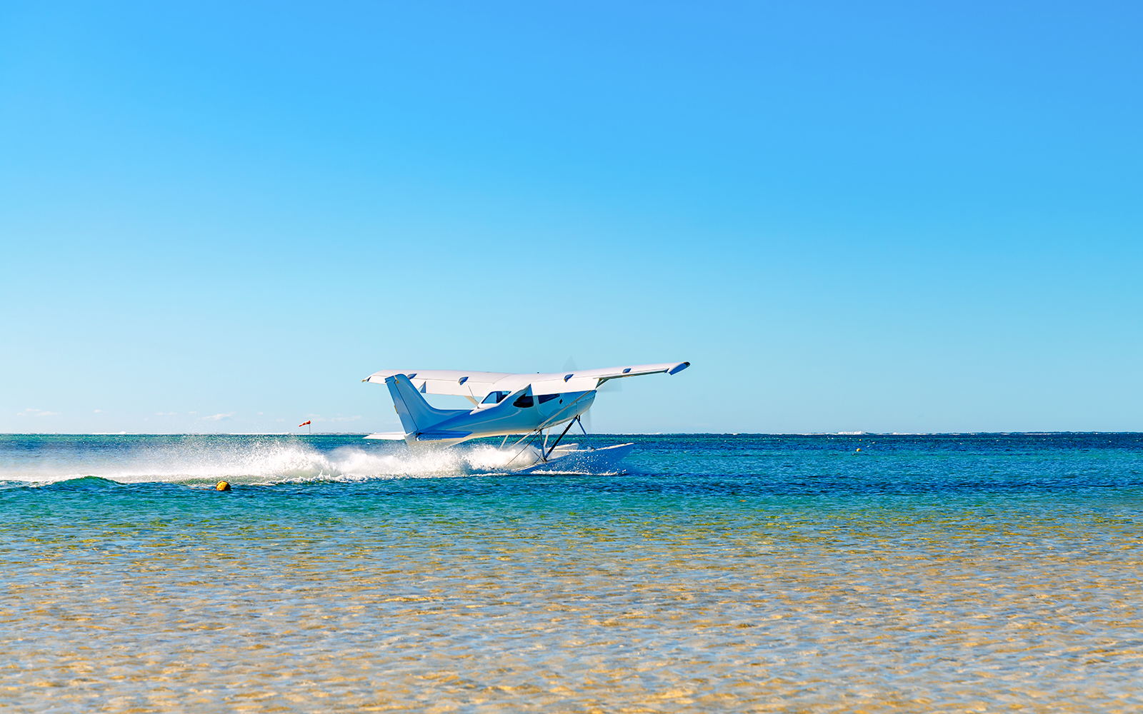 Seaplane taking off from turquoise waters in Mauritius.