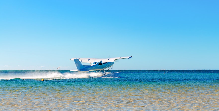 Seaplane taking off from turquoise waters in Mauritius.