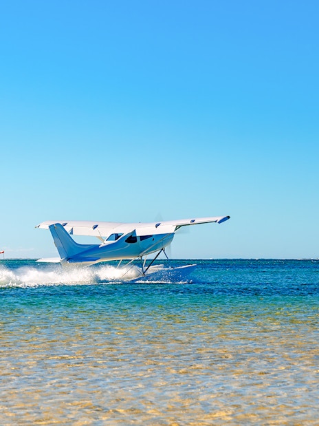 Seaplane taking off from turquoise waters in Mauritius.