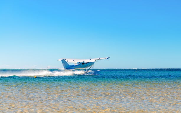 Seaplane taking off from turquoise waters in Mauritius.