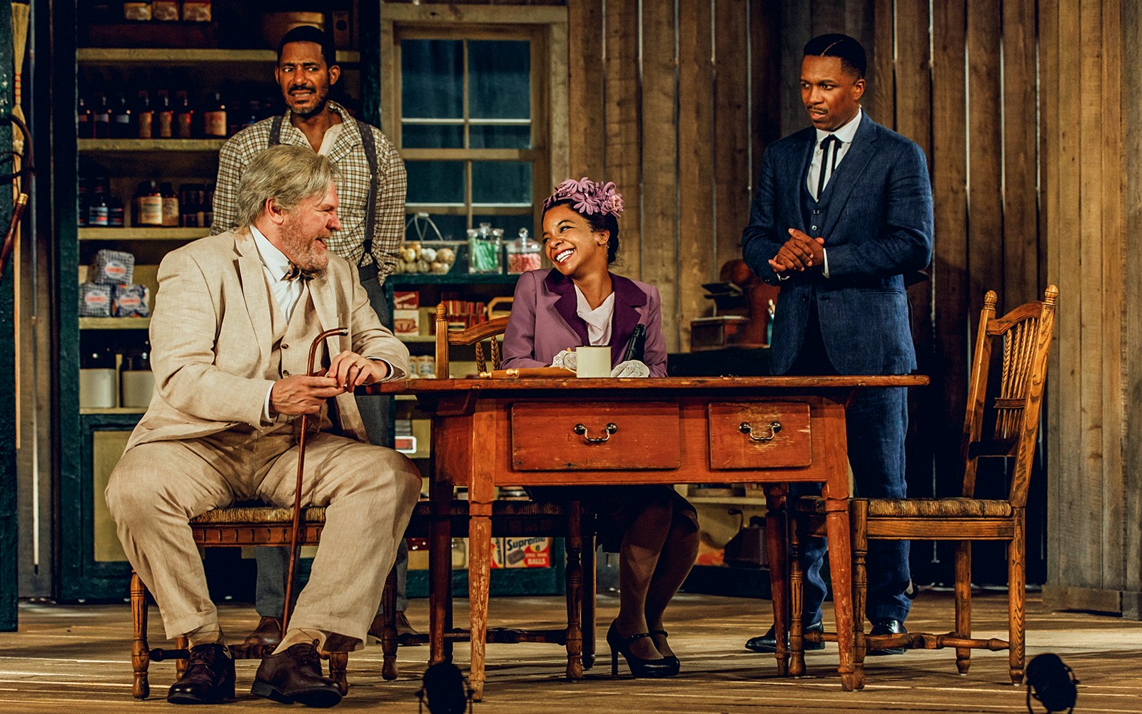 Actors performing a scene from "Purlie Victorious" in a rustic setting.