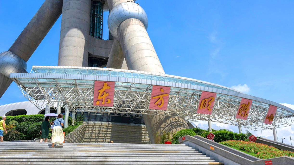 Entrance of Oriental Pearl Tower in Shanghai with visitors on steps.