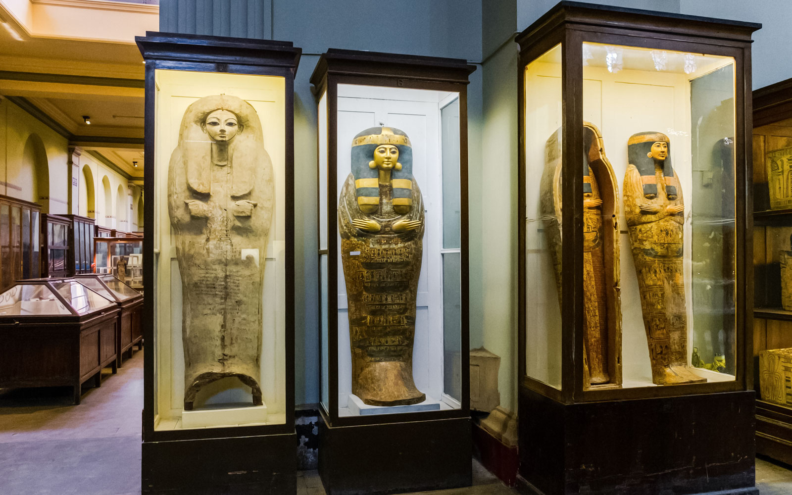 Ancient Egyptian sarcophagi displayed in a museum exhibit.