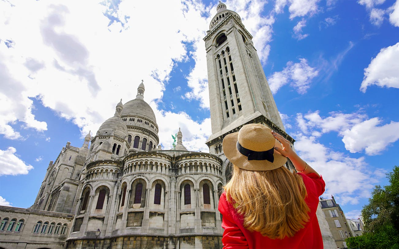 Tourist woman in Paris admiring the Basilica of the Sacred Heart.