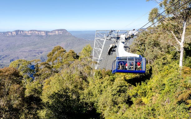 Cable car over Blue Mountains forest with distant cliffs, part of Zig Zag Train and Scenic World tour.